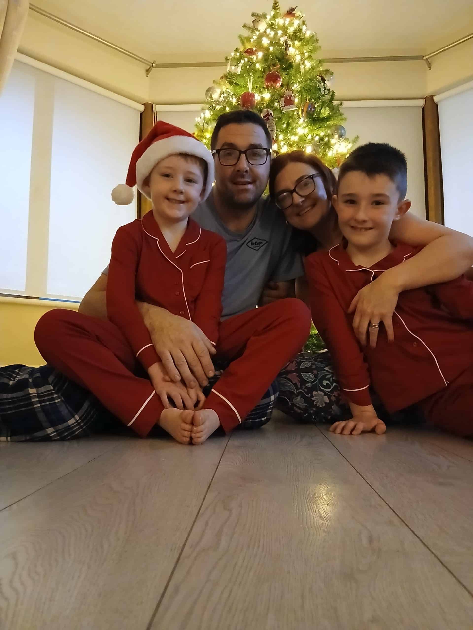 Family enjoying Christmas with decorated tree and holiday cheer.