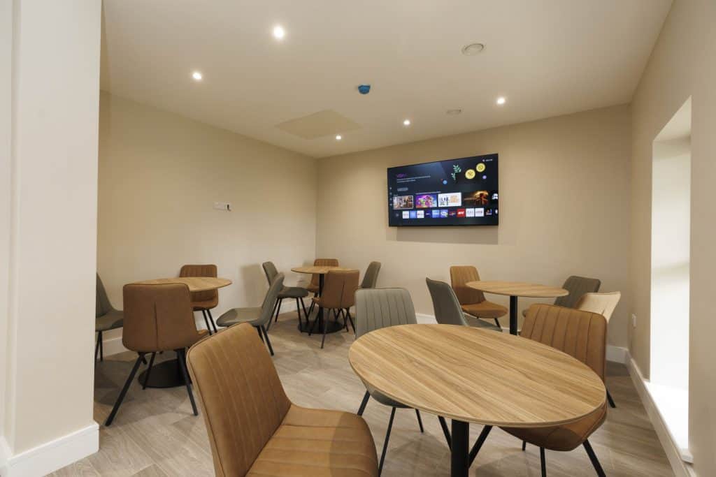 Modern kidney support centre room with tables and chairs for patient comfort.